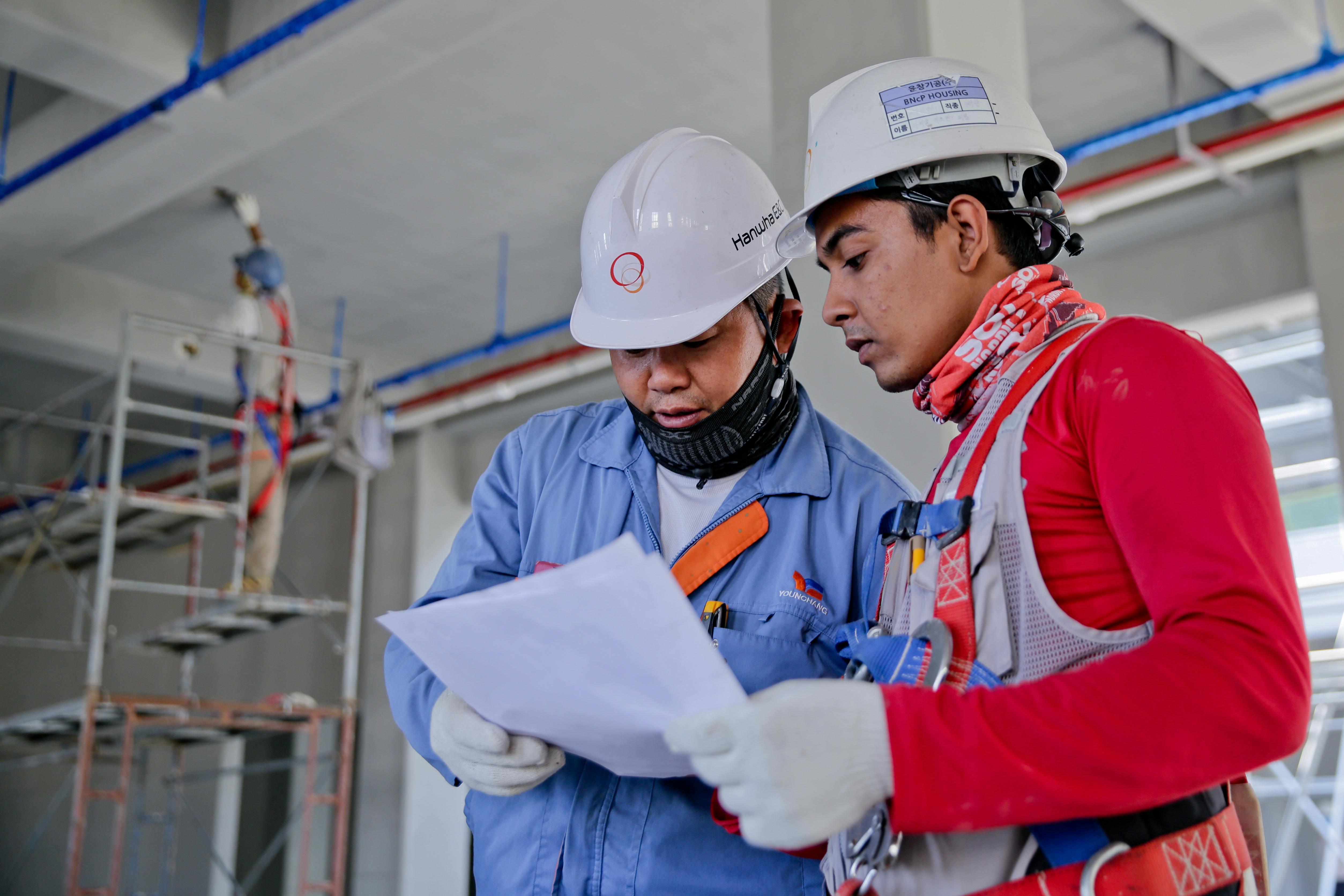 Engenheiros discutindo planos de compra em um canteiro de obras